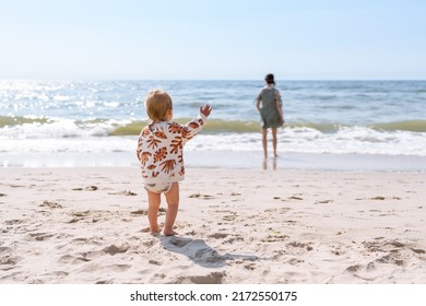 toddler calling his mother at the beach. Conceptual photo of mother-child relationship, separation anxiety, and attachment theory.