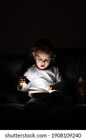 Toddler Caucasian Girl Reading Book At Hight With Flashlight. Unplugged Childhood Activities. Goodnight Bedtime Routine. Reading Fantasy Farytale