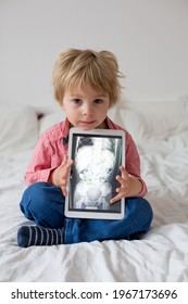 Toddler Child, Blond Boy, Holding X-ray Picture On Tablet Of Child Body With Swallowed Magnet Showing, Child Swallow Dangerous Object