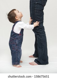 Toddler Child, Boy Or Girl, Standing By Mother's Legs, Looking Up