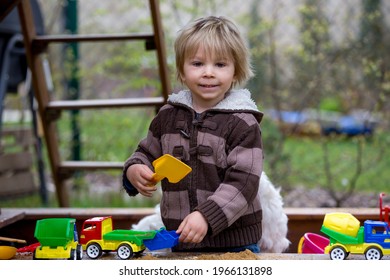 Toddler Child, Boy, Playing In Sandpit In Backyard In Garden