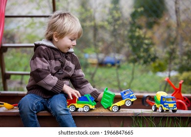 Toddler Child, Boy, Playing In Sandpit In Backyard In Garden