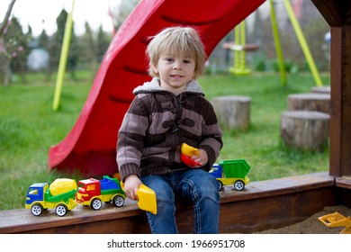 Toddler Child, Boy, Playing In Sandpit In Backyard In Garden