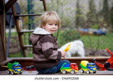 Toddler Child, Boy, Playing In Sandpit In Backyard In Garden