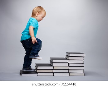A toddler climbing on a steps made of books - Powered by Shutterstock