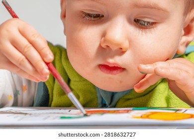 Toddler exploring colors while improving concentration and coordination.