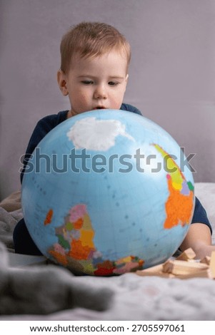 Toddler exploring a globe while imagining future travels