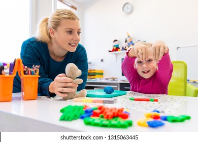 Toddler girl in child occupational therapy session doing sensory playful exercises with her therapist.  - Shutterstock ID 1315063445