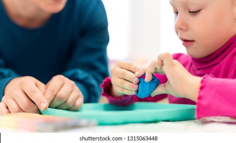 Toddler girl in child occupational therapy session doing sensory playful exercises with her therapist.  - Shutterstock ID 1315063448