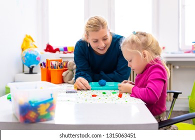Toddler girl in child occupational therapy session doing sensory playful exercises with her therapist.  - Shutterstock ID 1315063451