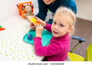 Toddler Girl In Child Occupational Therapy Session Doing Sensory Playful Exercises With Her Therapist. 