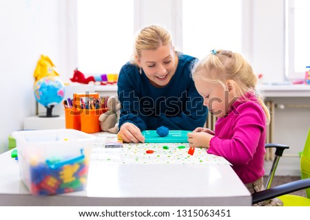 Toddler girl in child occupational therapy session doing sensory playful exercises with her therapist.  Stock foto © 