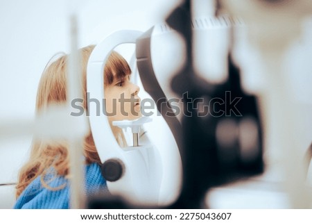 
Toddler Girl During Eye Examination with a Slit Lamp Microscope. Little patient having her retina check with a biomicroscope instrument 
