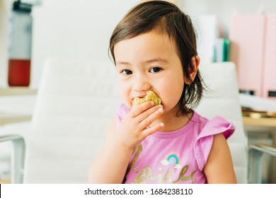 Toddler Girl Eating Banana Muffin