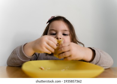 Toddler Girl Eating Bread Or Pie At Home With Her Hands. Hungry Kid. Unhealthy Diet. Bad Table Manners