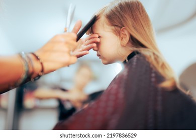 
Toddler Girl Getting Her Bangs Cute In A Professional Salon. Little Preschool Child Having A Haircut In A Beauty Studio
