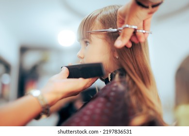 
Toddler Girl Getting Her Bangs Cute In A Professional Salon. Little Preschool Child Having A Haircut In A Beauty Studio
