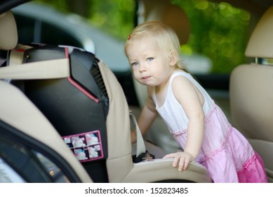 Toddler Girl Getting Into Her Car Seat