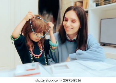 
Toddler Girl Having Fun Trying on Mom jewelry. Mom teaching daughter about developing a fashion sense at an early age
