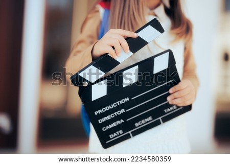 
Toddler Girl Holding a Film Slate interested in Acting Lessons. Little wannabe female director holding a film slate
