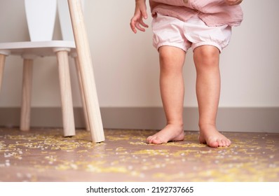 Toddler Girl Legs Standing On Messy Floor After Playing With Grain, Nuts, Pasta And Rice.Sensorial Early Development, Education For Baby, Child.Kids Dirty Room Concept.