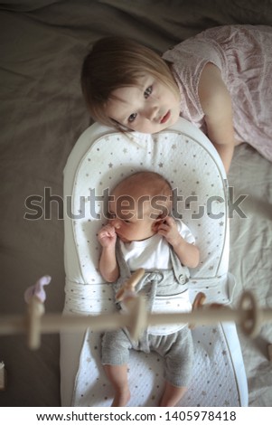 Similar – Image, Stock Photo Happy little girl holding doll and cookie while woman playing with a boy over the bed. Weekend family leisure time concept.