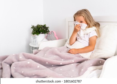 Toddler Girl Is Lying In Bed. The Child Is Cold And Sick And Has A Runny Nose And Snot. The Child Wipes His Nose With A Napkin. Allergy, Flu