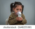 toddler girl making inhalation treatment with nebulizer br herself
