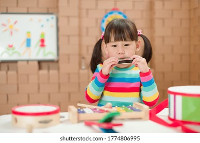 Toddler Girl Play Harmonica At Home For Homeschooling