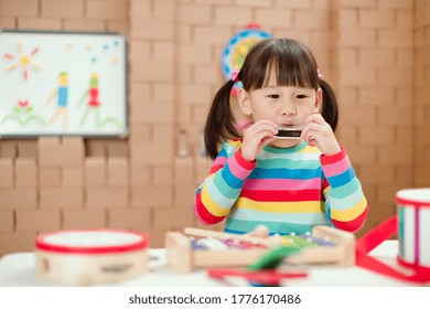 Toddler Girl Play Harmonica At Home For Homeschooling