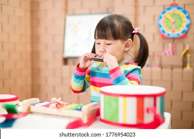 Toddler Girl Play Harmonica At Home For Homeschooling