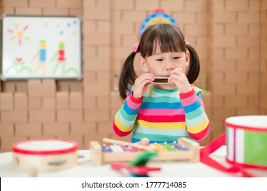 Toddler Girl Play Harmonica At Home For Homeschooling