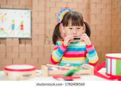 Toddler Girl Play Harmonica At Home For Homeschooling