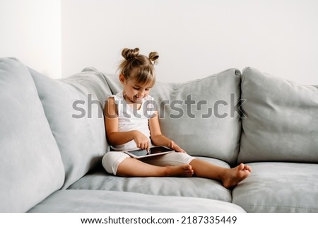 Similar – young caucasian little boy playing with tablet on couch