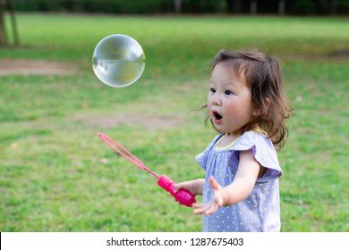 Toddler Girl Playing With Soap Bubbles