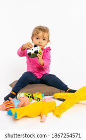 Toddler Girl Plays With Boy Toys And Looks At The Camera. Gender Stereotypes.