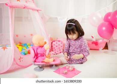 Toddler Girl Pretend Play Baby Care At Home Against White Background