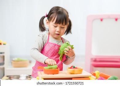 Toddler Girl Pretend Play Food Preparing Role At Home Agianst White Background