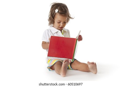 Toddler Girl Pretends To Read A Book Isolated On White Background