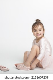 Toddler Girl Putting On Her Ballet Shoes With The Joy And Excitement For Her Photo Shooting