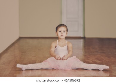 toddler girl sitting in cross split in ballet school