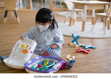 A Toddler Girl Wear Mask Playing Toy.