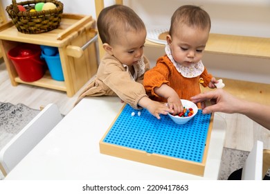 Toddler Girls Playing With Montessori Peg Board Wooden Material Practicing Fine Motor Skills