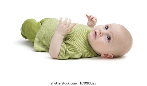 toddler in green clothing laying on back in white background