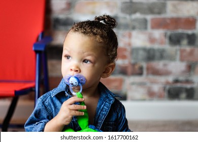 Toddler with pacifier looking into the distance. - Powered by Shutterstock