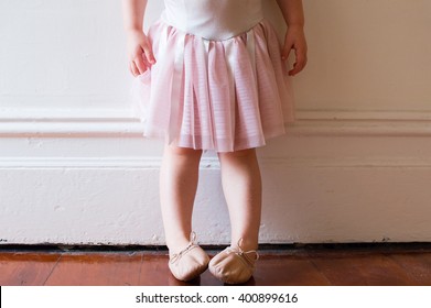 Toddler In Pink Tutu And Ballet Shoes Standing In Vintage Hallway (cropped)