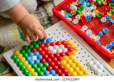 Toddler playing pegboard mosaic. Early child development. Fine motor skills. Learning and creativity - Shutterstock ID 2174112497
