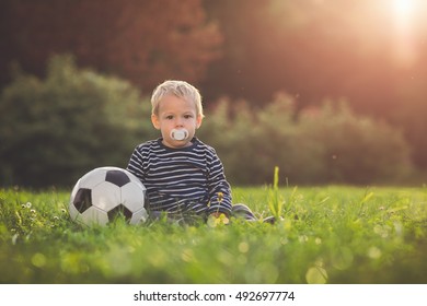 Toddler Playing With A Soccer Ball In The Sunset