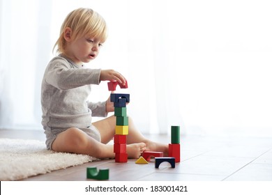 Toddler Playing With Wooden Blocks At Home