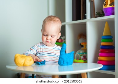 Toddler Plays Colorful Plasticine Play Dough And Copy Space. Development Of Children From Birth.